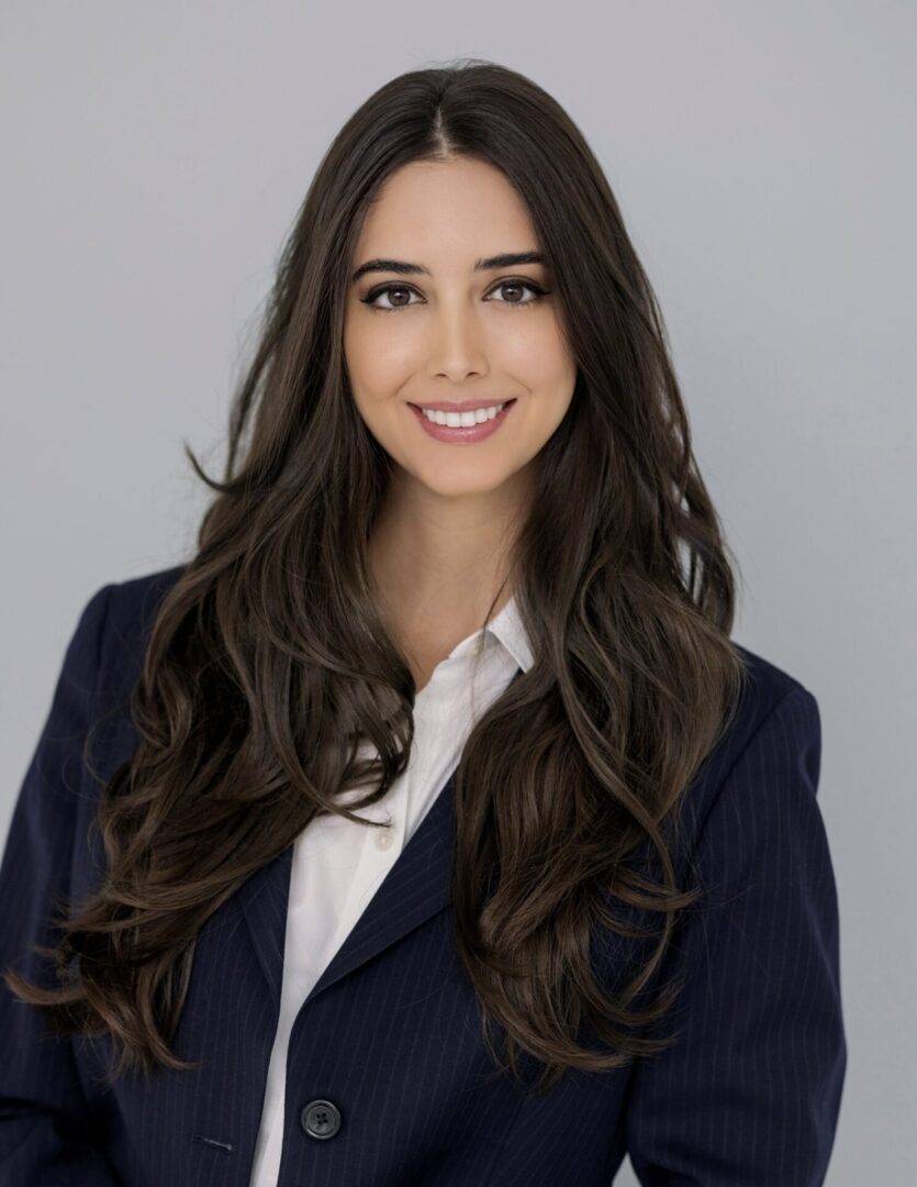 A woman wearing blue suit with white shirt standing