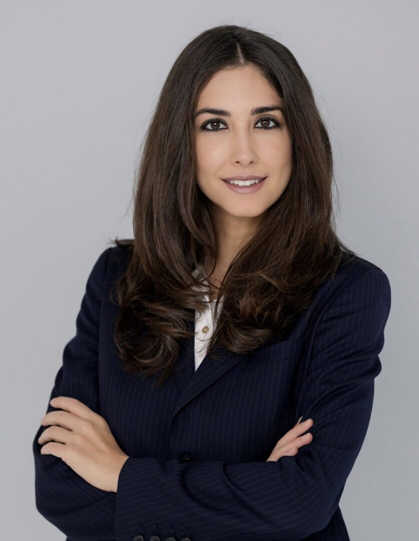 A woman in a suit poses for the camera.